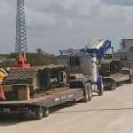 Heavy machinery being hauled by fleet trucks