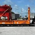 Heavy load of construction beams on orange flatbed