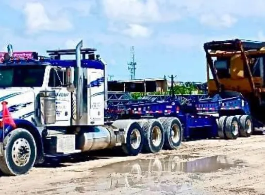 blue and white diesel truck waiting for oversized load