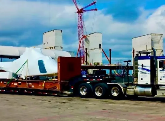 heavy oversized cargo on red flatbed connected to a truck